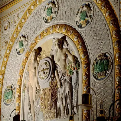 a statue of a woman with a clock on a wall at Art Deco Imperial Hotel in Prague