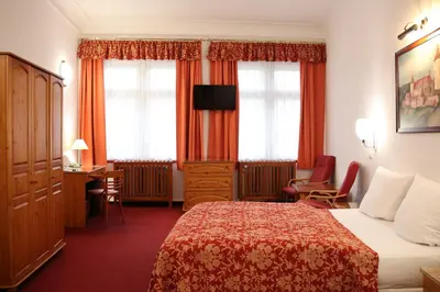 a hotel room with a bed and a desk at Unitas Residence in Prague