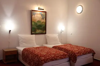 a hotel room with two beds and a painting on the wall at Unitas Residence in Prague