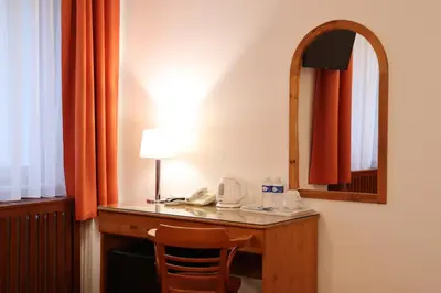 a room with a desk with a lamp and a mirror at Unitas Residence in Prague