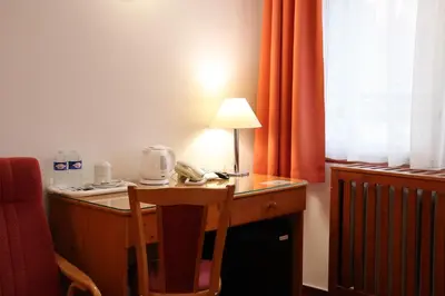 a desk with a telephone and a lamp on it at Unitas Residence in Prague
