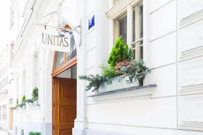 a sign on a building with plants in a window at Unitas Residence in Prague