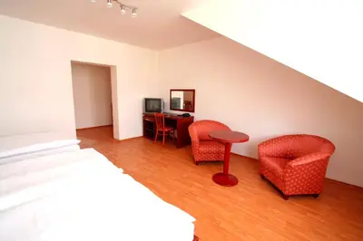 a bedroom with a bed and two chairs and a desk at Apart Hotel Susa in Prague