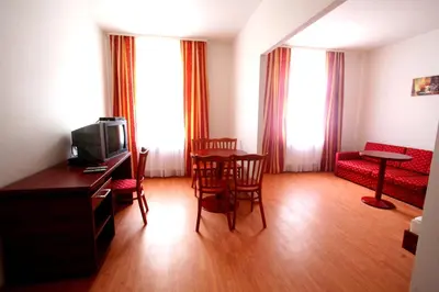 a living room with a tv and a table and chairs at Apart Hotel Susa in Prague