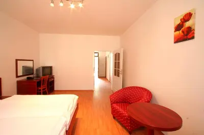 a bedroom with a bed and a table and a chair at Apart Hotel Susa in Prague
