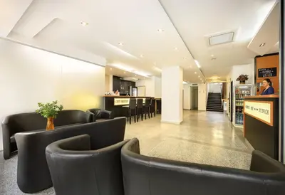 a waiting room with black chairs and a kitchen at Residence BENE in Prague