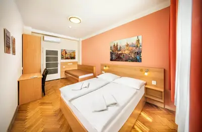 a bedroom with a large white bed and orange walls at Residence BENE in Prague