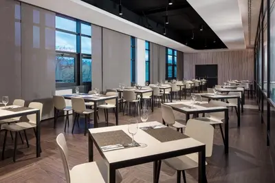 a restaurant with tables and chairs and windows at Clarion Congress Hotel Prague in Prague