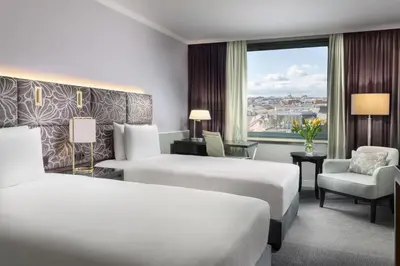 a hotel room with a desk and a vase of yellow flowers at Hilton Prague Old Town in Prague