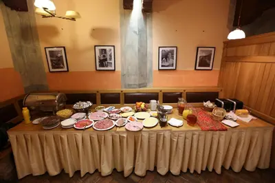 a table with many plates of food on it at Hotel King George in Prague