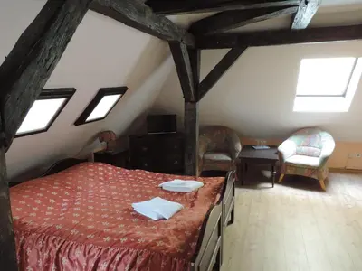 a bedroom with a bed and two chairs in a attic at Hotel King George in Prague