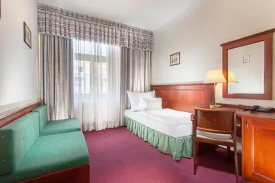 a hotel room with a bed and a desk and a chair at Hotel Lunik in Prague