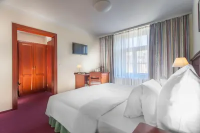 a hotel room with a white bed and a window at Hotel Lunik in Prague