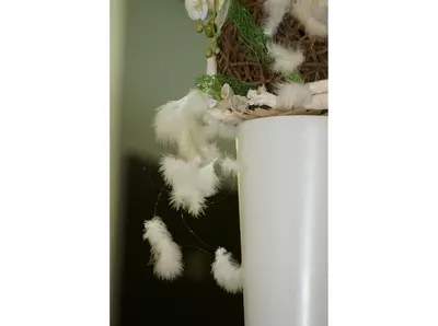 a white vase with some feathers in it at Hotel Lunik in Prague