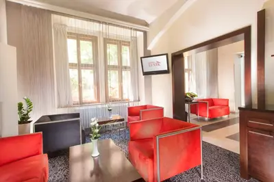 a living room with red chairs and a mirror at Hotel Lunik in Prague