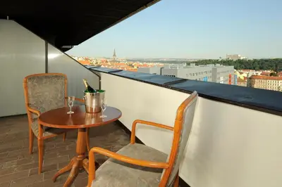 a table and chairs on a balcony with a view at Congress & Wellness Hotel Olsanka in Prague