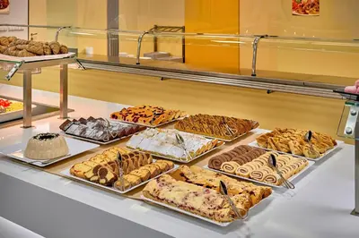 a display case filled with different types of pastries at Congress & Wellness Hotel Olsanka in Prague