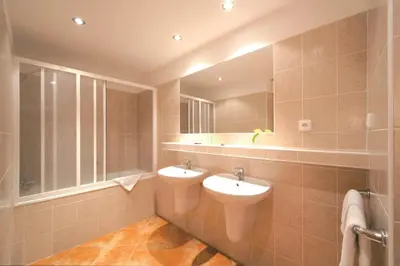 a bathroom with two sinks and a large mirror at Congress & Wellness Hotel Olsanka in Prague
