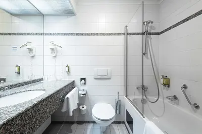 a bathroom with a toilet and a sink and a shower at Grand Hotel International - Czech Leading Hotels in Prague