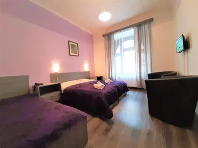 a hotel room with two beds and a window at Hotel Olga in Prague