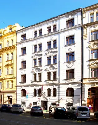 a white building with cars parked in front of it at Hotel Olga in Prague