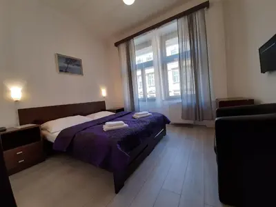 a bedroom with a bed and a large window at Hotel Olga in Prague