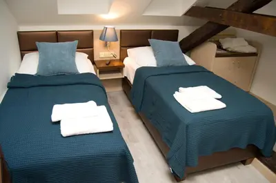two beds in a room with blue and white sheets at U Medvidku-Brewery Hotel in Prague