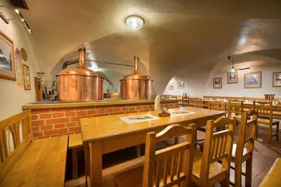 a dining room with a table and some copper pots at U Medvidku-Brewery Hotel in Prague