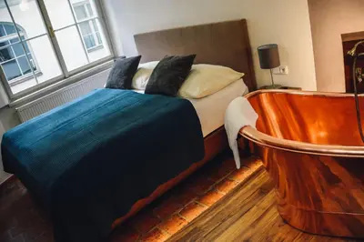 a bedroom with a bed and a large window at U Medvidku-Brewery Hotel in Prague
