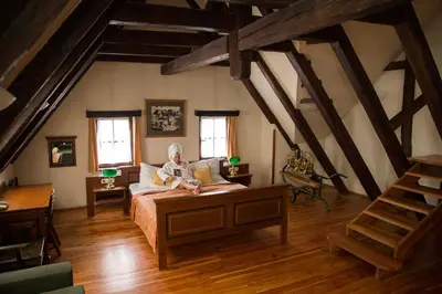 a man sitting on a bed in a attic at U Medvidku-Brewery Hotel in Prague
