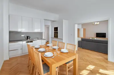 a kitchen and dining room with a wooden table and chairs at Downtown Suites Kodanska in Prague