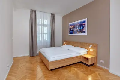 a bedroom with a bed and a window at Downtown Suites Kodanska in Prague