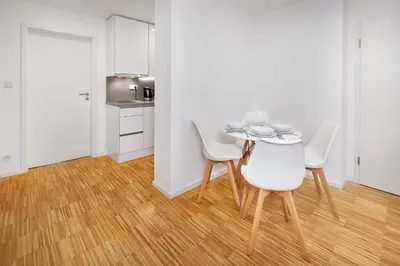 a white dining room with a table and chairs at Downtown Suites Kodanska in Prague