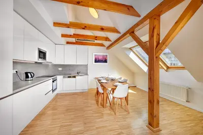 a kitchen and dining room with a table and chairs at Downtown Suites Kodanska in Prague