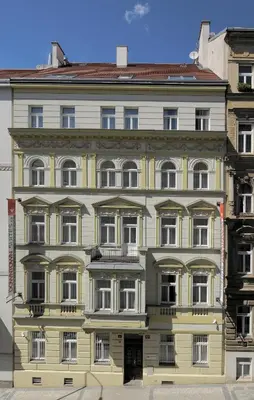 a large yellow building with white windows at Downtown Suites Kodanska in Prague