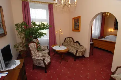 a living room with two chairs and a table and a television at Hotel Opera in Prague