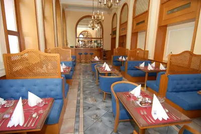a restaurant with blue chairs and tables with napkins on them at Hotel Opera in Prague