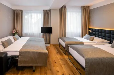 a hotel room with three beds in a room at Hotel Aida in Prague