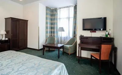 a hotel room with a bed and a desk and a television at EA Hotel Downtown in Prague