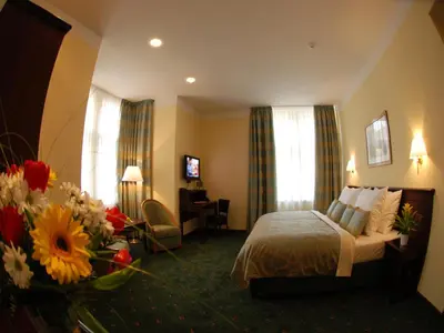 a hotel room with a bed and flowers in a room at EA Hotel Downtown in Prague