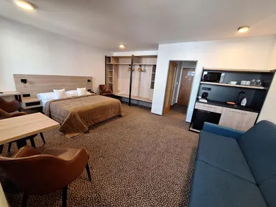 a large living room with blue couches and windows at Hotel Avion in Prague