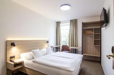 a hotel room with a bed and a chair at Hotel Avion in Prague