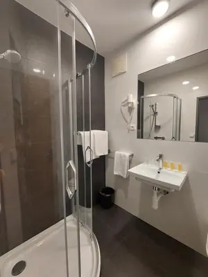 a hotel room with a large bed and a couch at Hotel Avion in Prague
