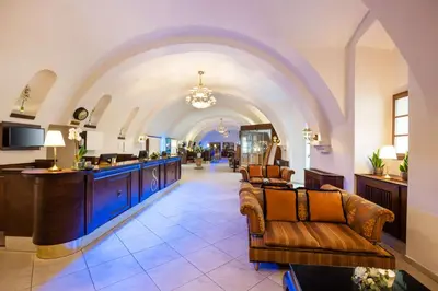 a lobby with an archway with chairs and a salon at Lindner Hotel Prague Castle, part of JdV by Hyatt in Prague