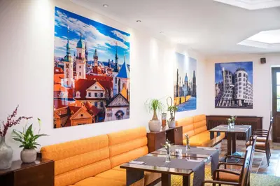 a restaurant with two tables and a large painting on the wall at Lindner Hotel Prague Castle, part of JdV by Hyatt in Prague