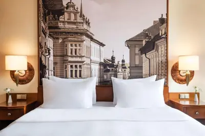 a bedroom with two white beds and a city view at Lindner Hotel Prague Castle, part of JdV by Hyatt in Prague