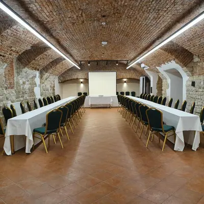a conference room with tables and chairs and a white screen at Michelangelo Grand Hotel in Prague