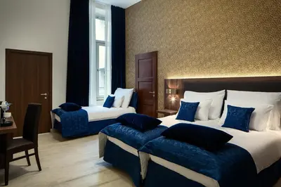 a hotel room with two beds with blue pillows at Michelangelo Grand Hotel in Prague