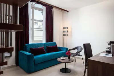 a living room with a green couch and a table at Michelangelo Grand Hotel in Prague