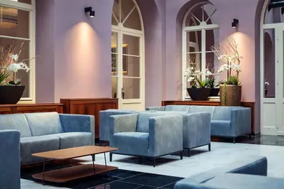 a waiting room with blue chairs and tables at Michelangelo Grand Hotel in Prague
